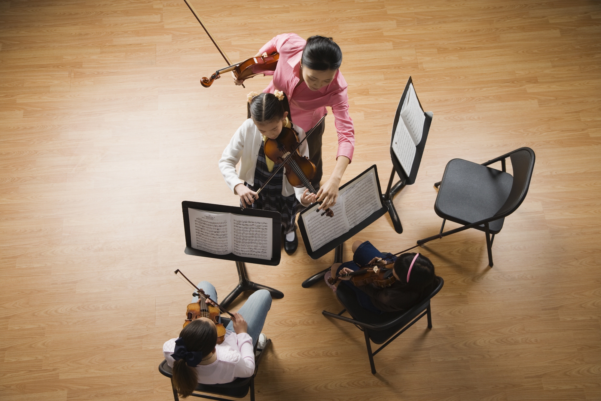 Aerial view of three music stands, two students and a teacher