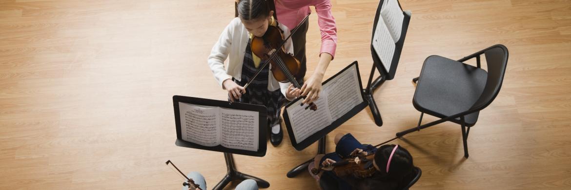 Aerial view of three music stands, two students and a teacher