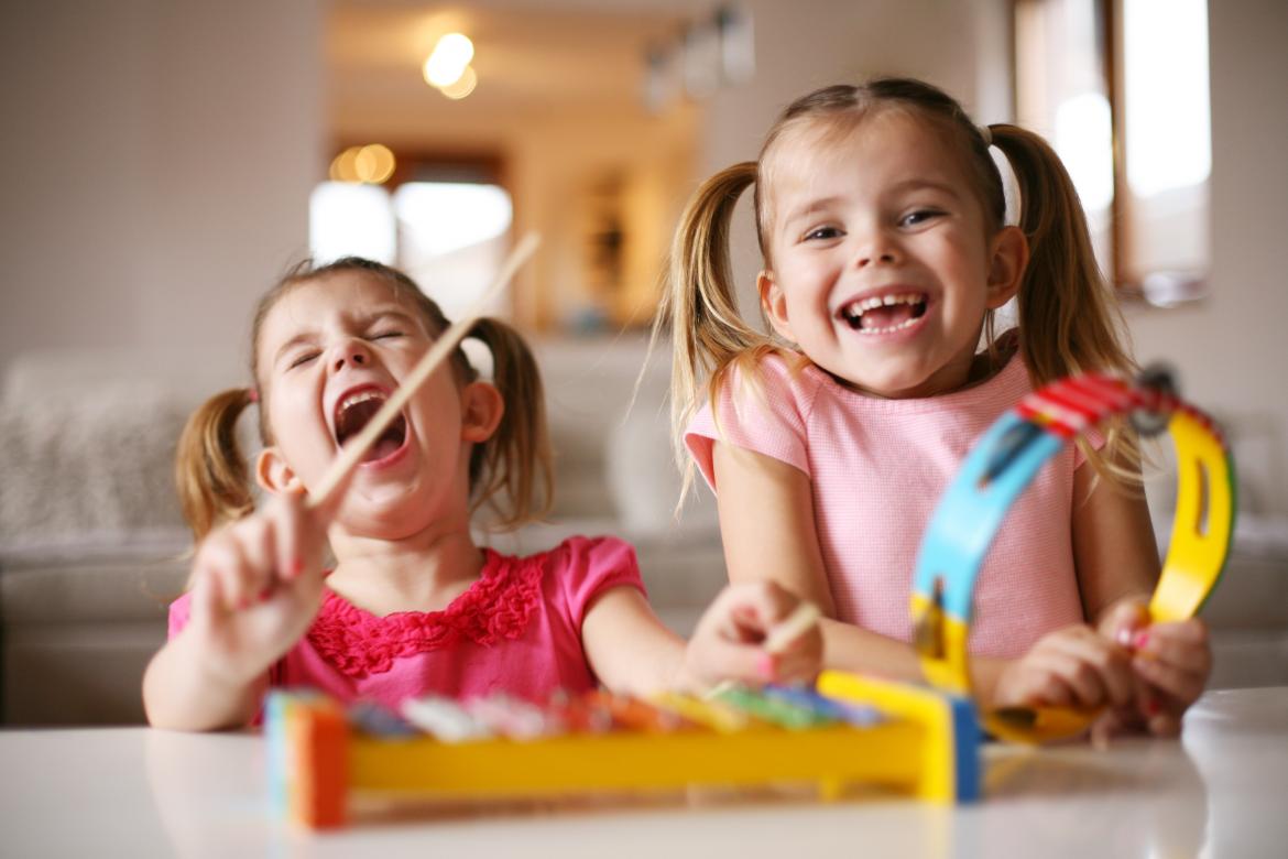 two little kids on a kids xylophone having great fun