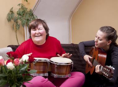 Young student playing music with her teacher