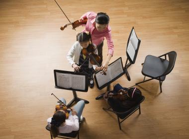 Aerial view of three music stands, two students and a teacher