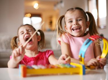 two little kids on a kids xylophone having great fun